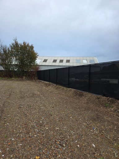 Onkruid verwijderen langs hekwerk in Bergen op Zoom